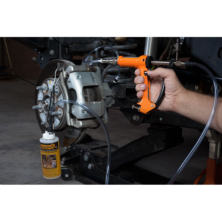 The image shows a mechanic using a brake fluid bleeding gun to bleed a brake caliper on a car.