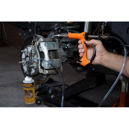 The image shows a mechanic using a brake fluid bleeding gun to bleed a brake caliper on a car.