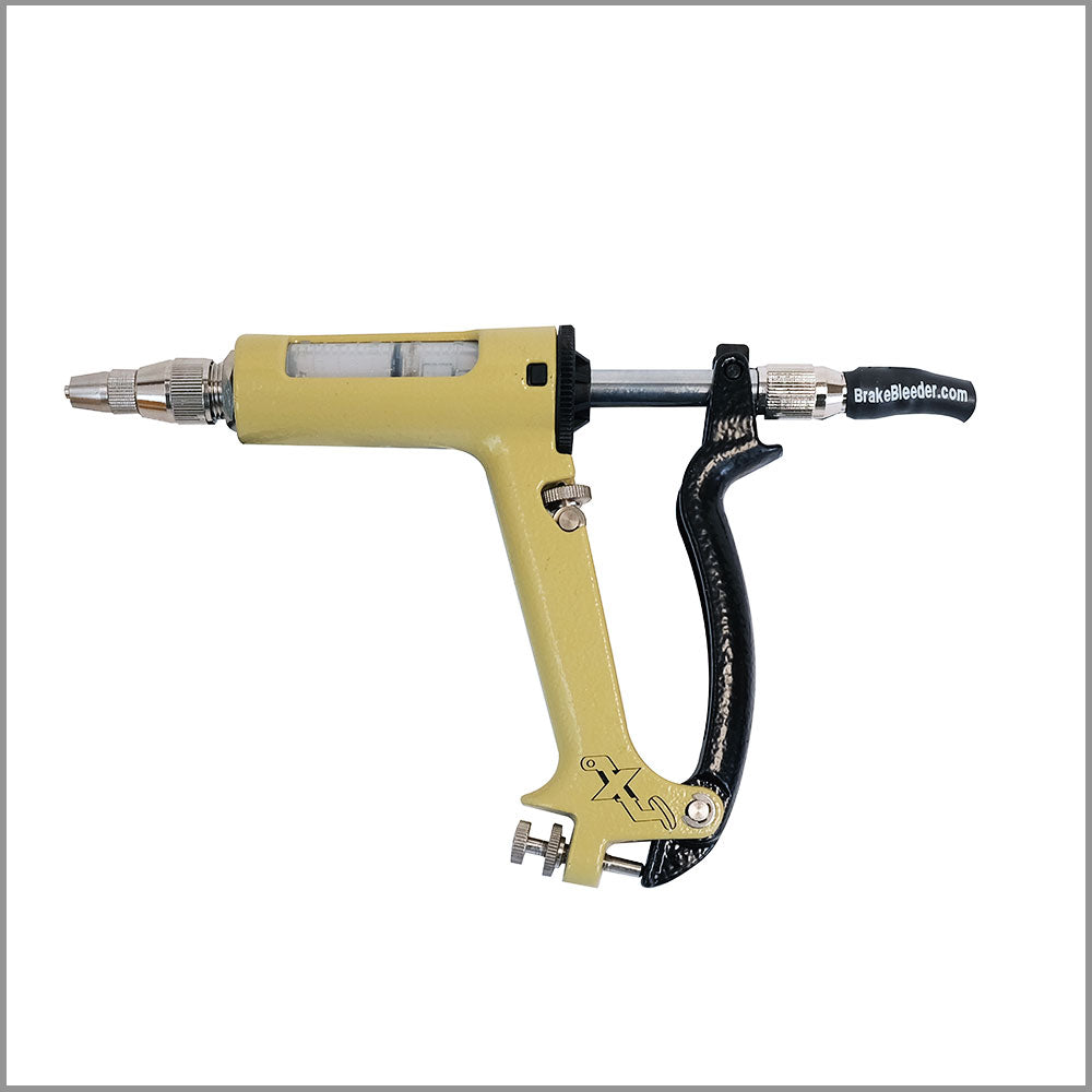 The image shows a yellow and black MaxProHD Brake & Clutch Bleeder. It is a close-up of a syringe-like tool with a yellow barrel and a black handle. The text “BrakeBleeder.com” is printed on the barrel.  A syringe-like tool is used to inject fluid into a system. In this case, the MaxProHD Brake & Clutch Bleeder is used to bleed brakes and clutches, which means removing air bubbles from the system.